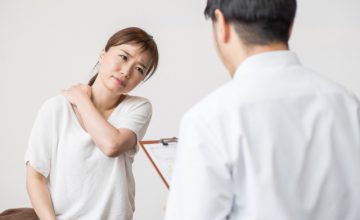 肩こりの悩みを整骨院で相談する女性